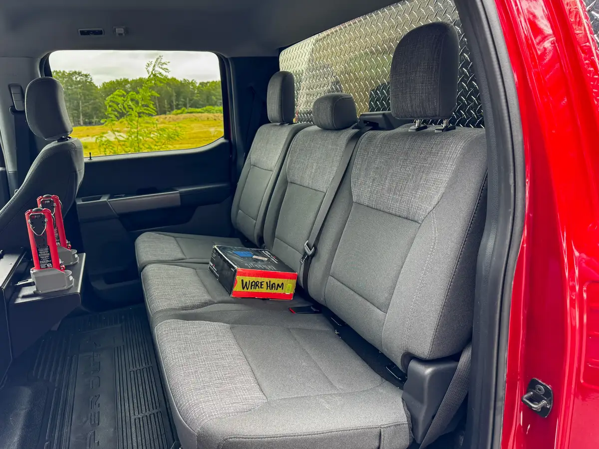 Rear bench-seat close-up showing three-seat layout and seatbelt positions.